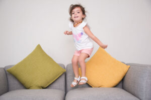Criança pulando no sofá