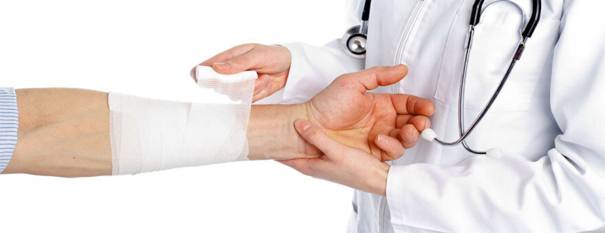 médico enfaixando o braço do paciente