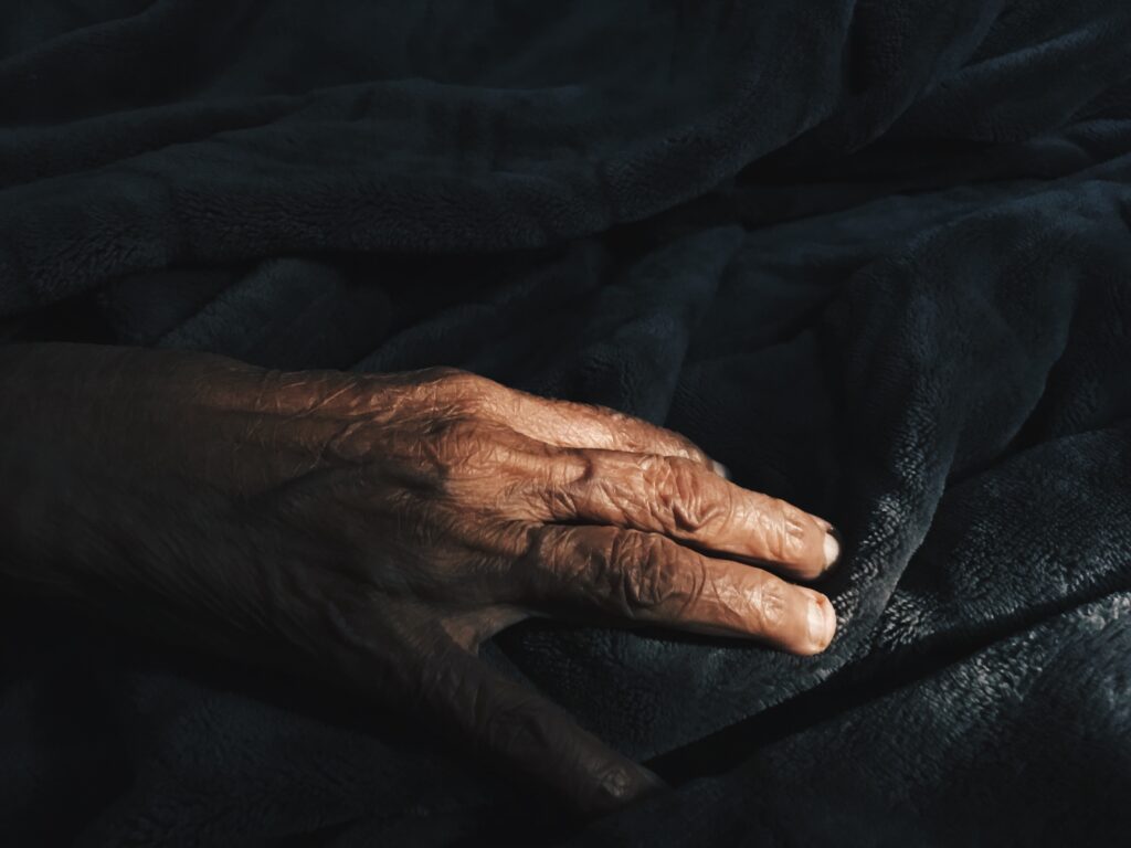 mão de idoso na cama